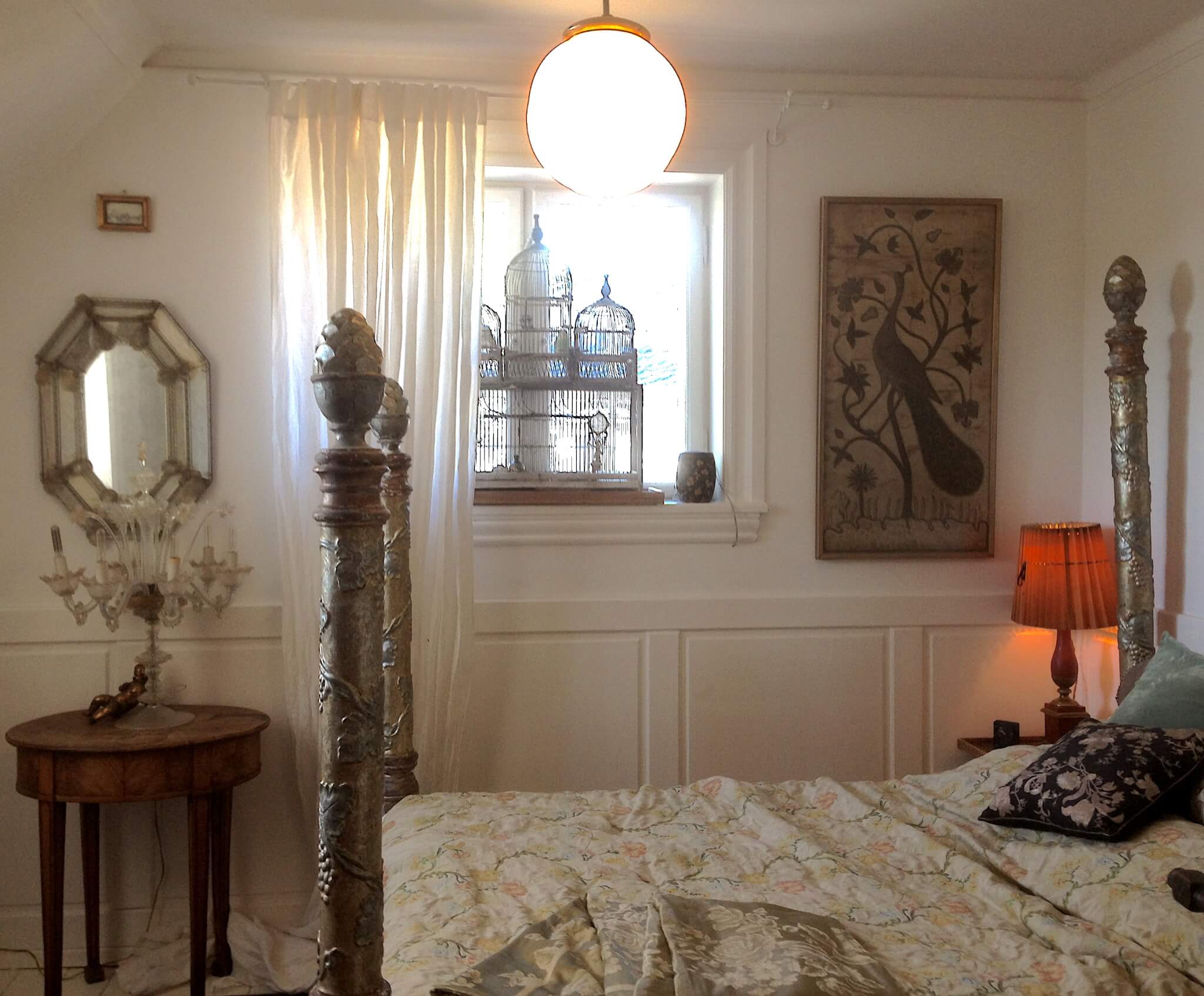 Soveværelse med venetiansk seng, lampe og spejl